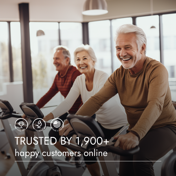 Group of older adults exercising on stationary bikes in a well-lit room.