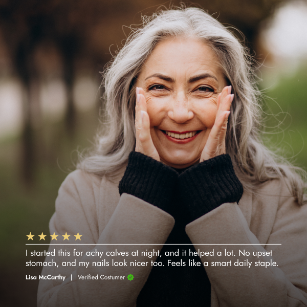 Woman with gray hair smiling outdoors, wearing a coat and scarf.